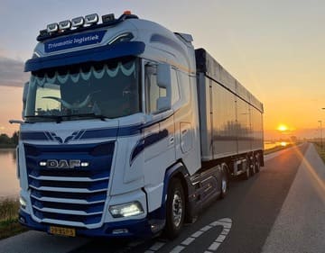 Vrachtwagen van Triomatic Logistiek op de weg met mooie zonsondergang mobiel